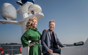 two individuals posing on a yacht