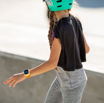 skateboarding girl wearing smart watch while riding