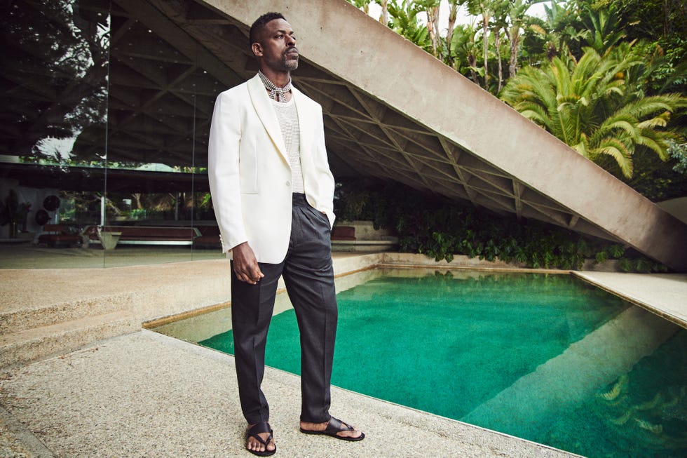 a man in a suit standing next to a pool