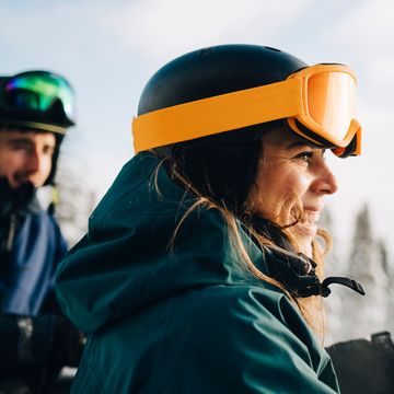 man and woman wearing ski helmets and goggles