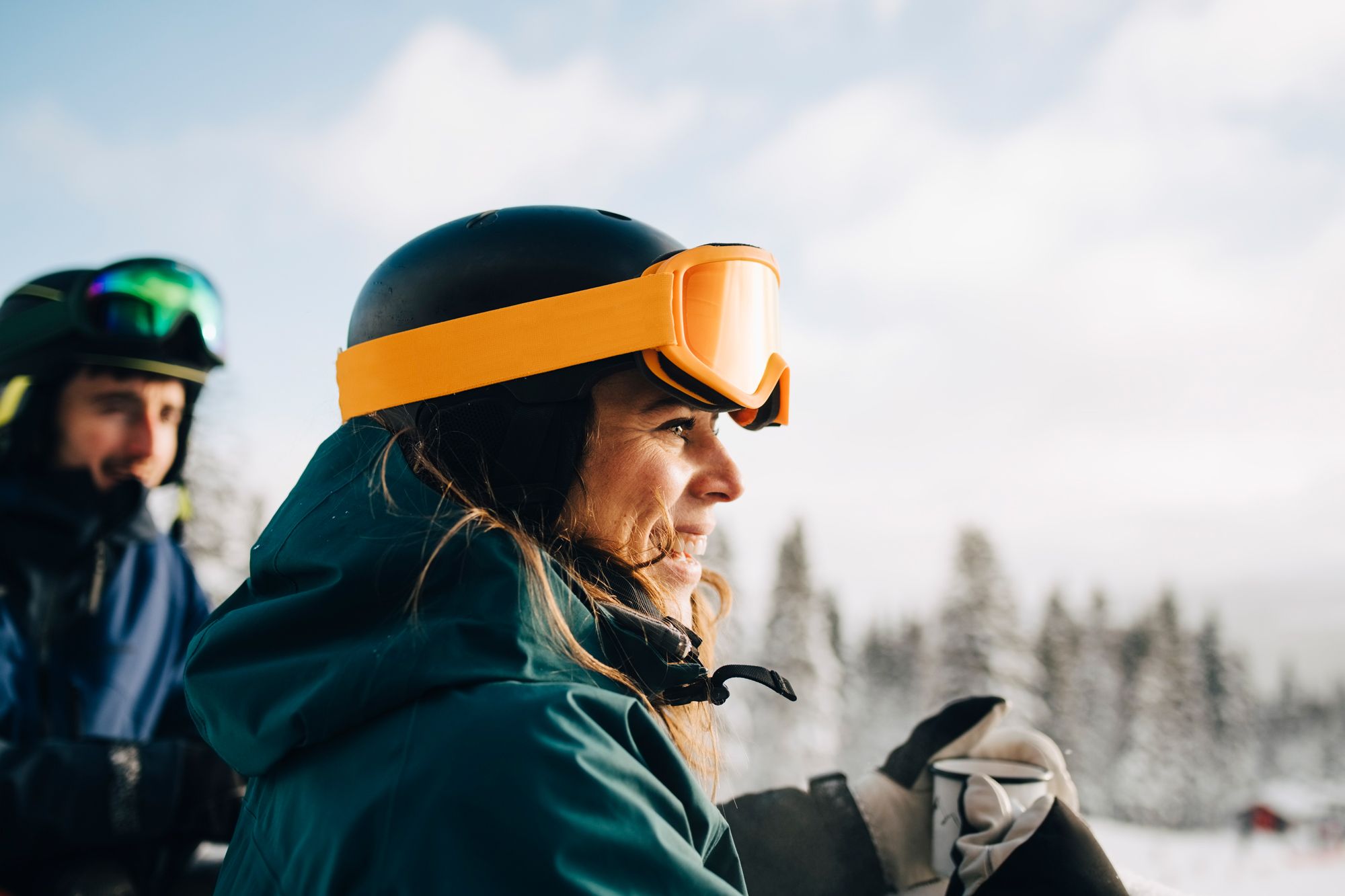 man and woman wearing ski helmets and goggles
