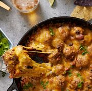 chili and meatballs in a cast iron skillet, topped with melty cheese