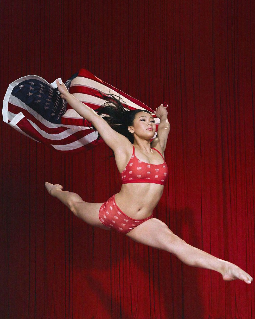 a woman in red underwear jumping in the air holding an american flag