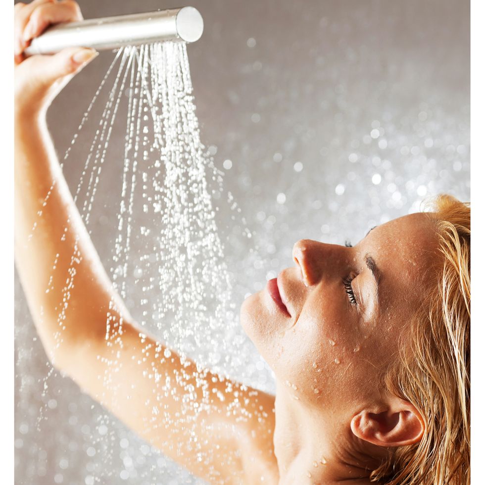 Young woman bathing under an shower.