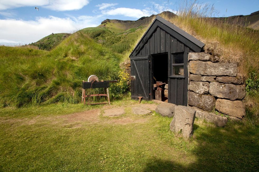 Een traditioneel turfdak beschermt een houten huis in IJsland