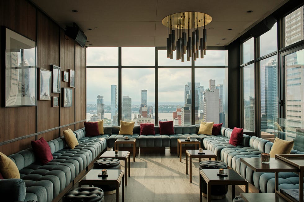 a room with a couch and a table with a view of the city