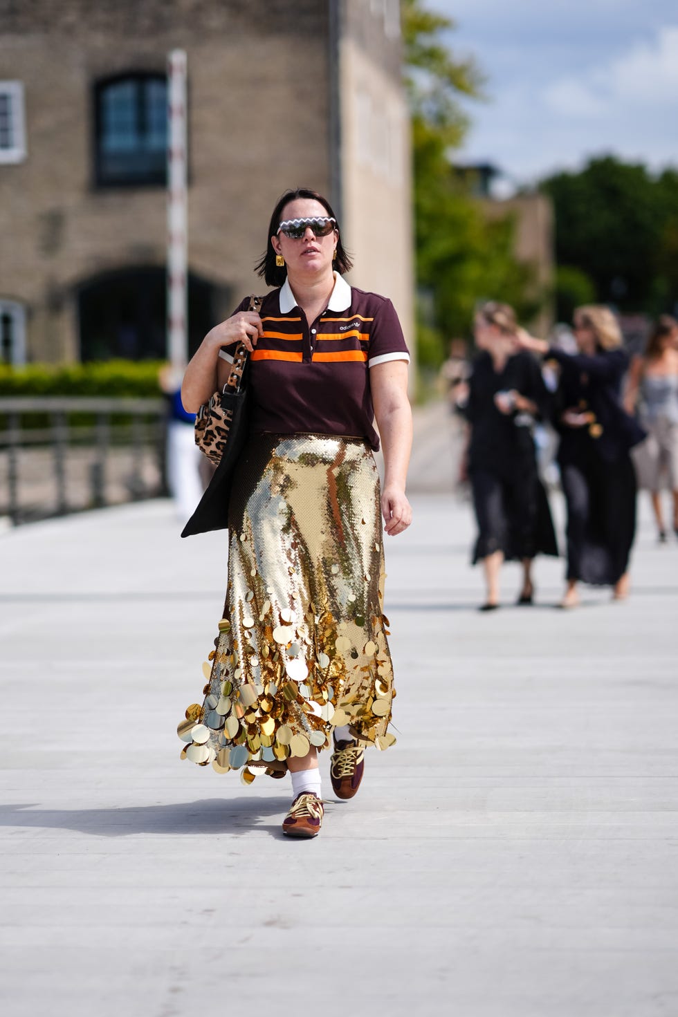 a street style photo of a guest at copenhagen fashion week wearing adidas sl 72 trainers