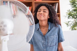 vrouw zit voor een ventilator