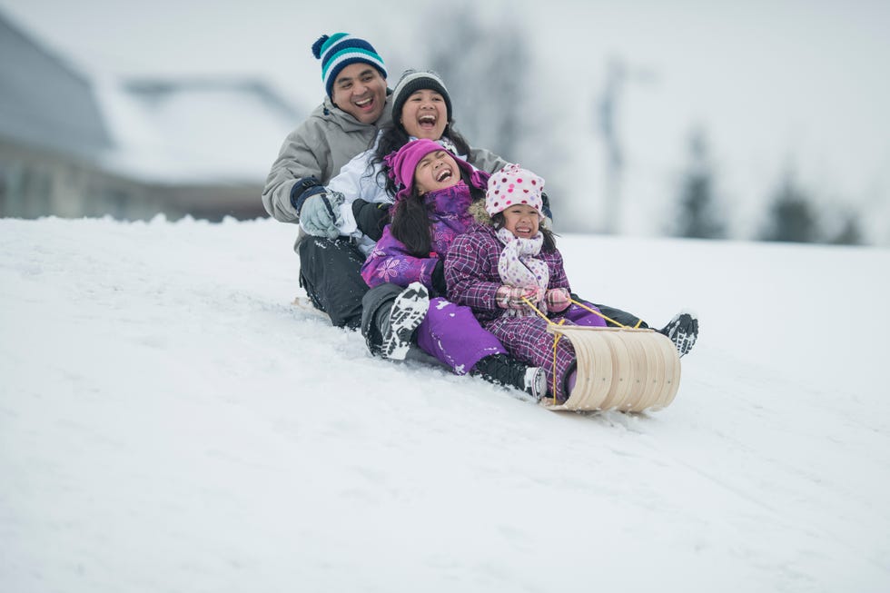 a family sledding on an old fashioned sled
