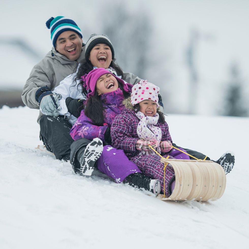 a family sledding on an old fashioned sled