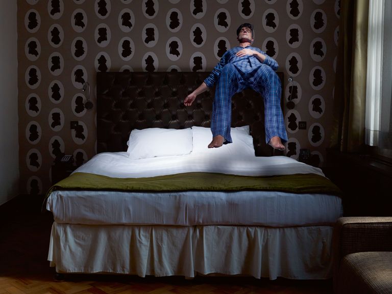 a man jumping on a bed