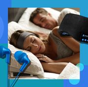woman using sleep headphones in bed