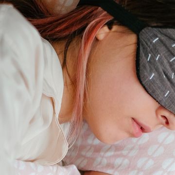 woman wearing sleep mask in bed