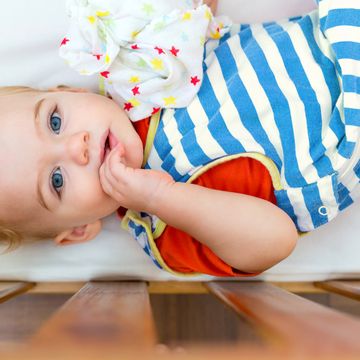 baby wearing striped sleep sack in crib
