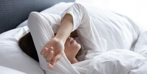 sleepless young woman suffering from insomnia, covering eyes with hands