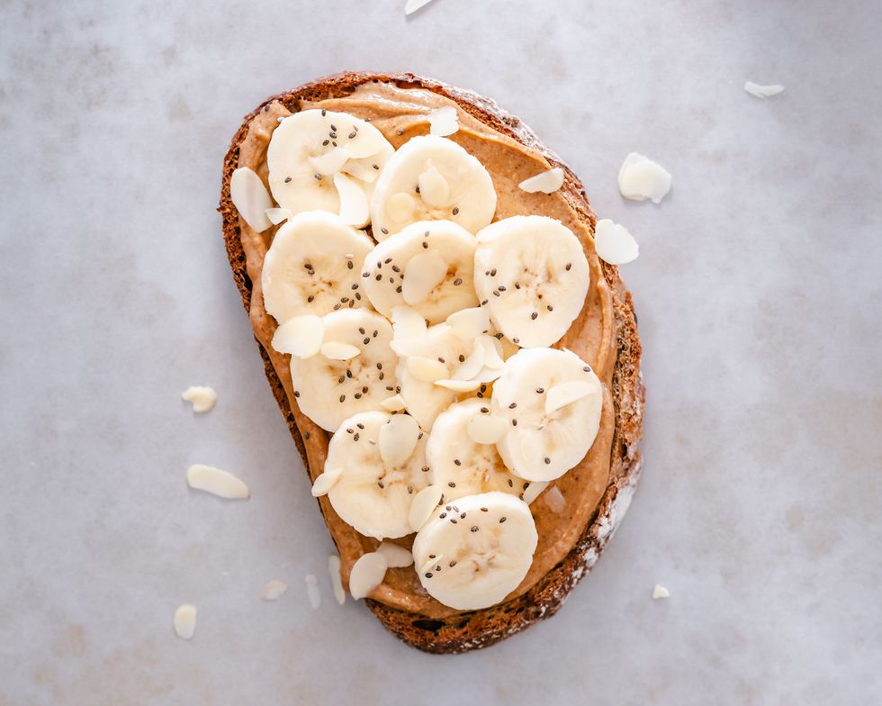 slice of sourdough toast with peanut butter, banana, chia seeds and almond flakes