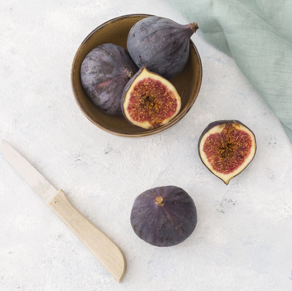 sliced and whole fresh figs, kitchen knife and cloth