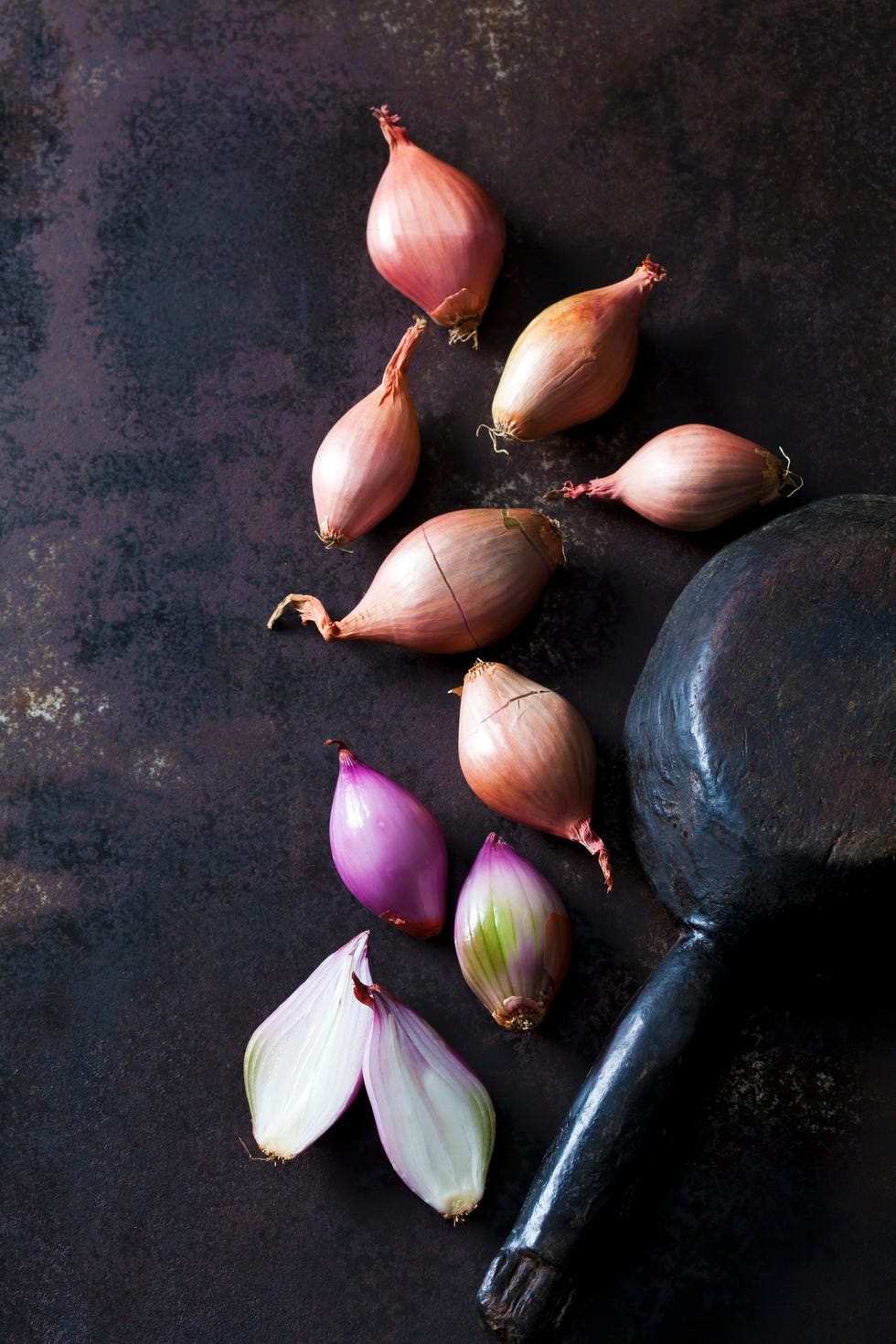 sliced and whole shallots on rusty ground