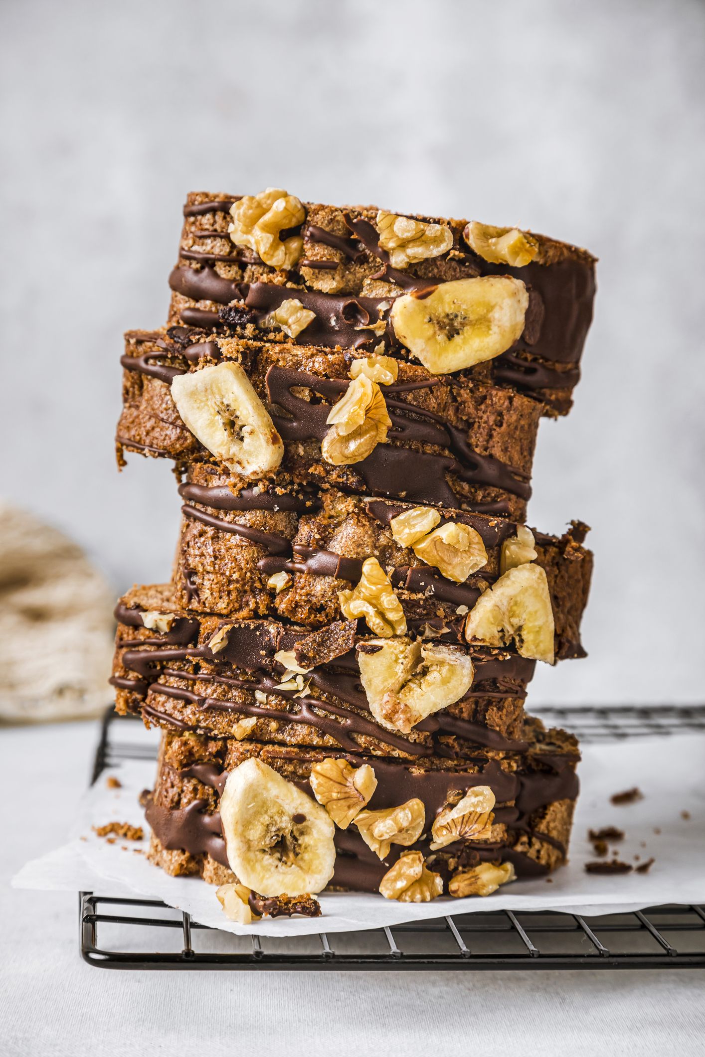 https://hips.hearstapps.com/hmg-prod/images/sliced-banana-cake-with-walnuts-and-chocolate-sauce-royalty-free-image-1678127658.jpg