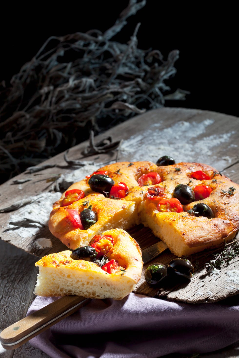 Sliced foccaccia with black olives, tomatoes and oregano
