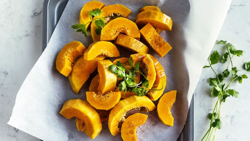 sliced, fresh butternut squash on parchment on a tray