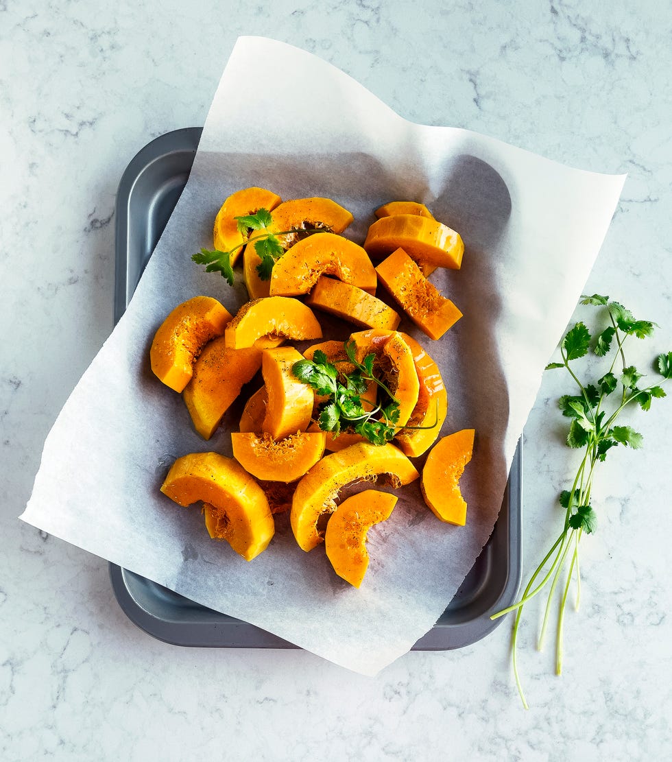 sliced, fresh butternut squash on parchment on a tray
