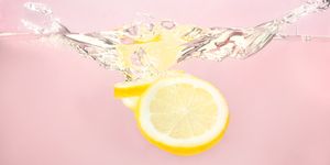Sliced lemons splashing in water