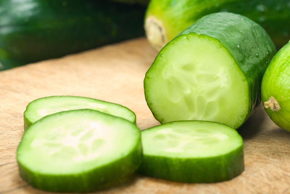 Sliced up cucumbers on wooden board