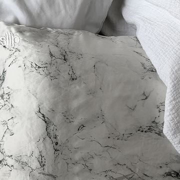 marble slip silk pillowcase on bed with white duvet cover
