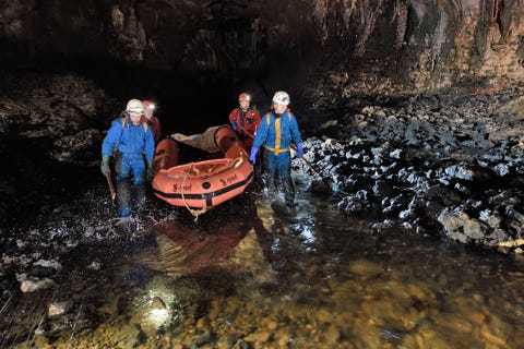 Bij een lagere waterstand van de rivier moest het team zijn rubbervlot vaak over drooggevallen gedeelten van de bedding dragen Hier in de Planinska jama is het team op weg naar de plek waar de rivieren Rak en Pivka elkaar ontmoeten een van de grootste onderaardse samenlopen in Europa