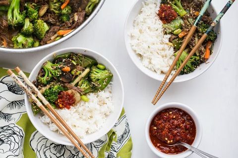 shredded beef and broccoli stir fry over rice with chopsticks