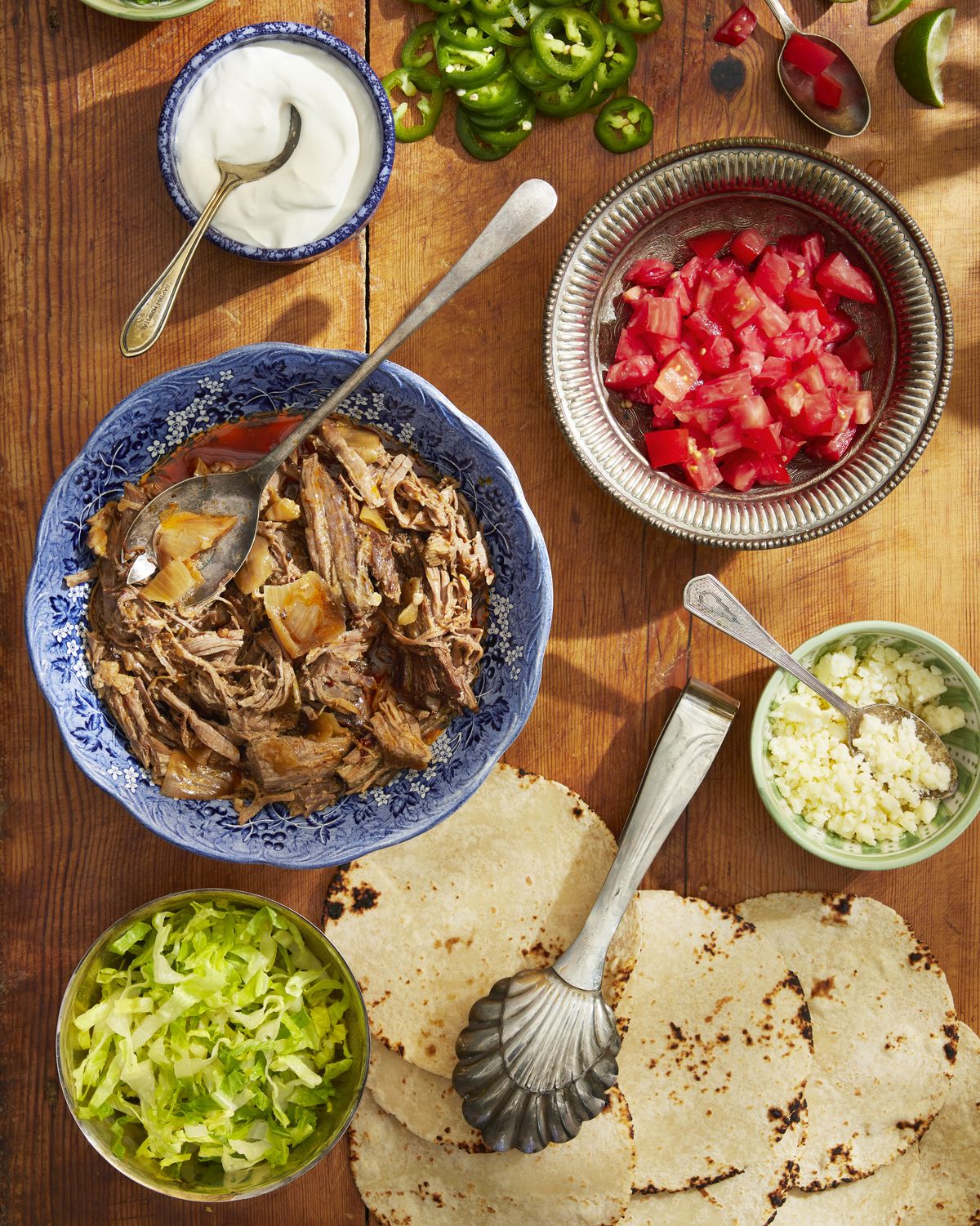 slow cooker beef taco ingredients in bowls on a cutting board