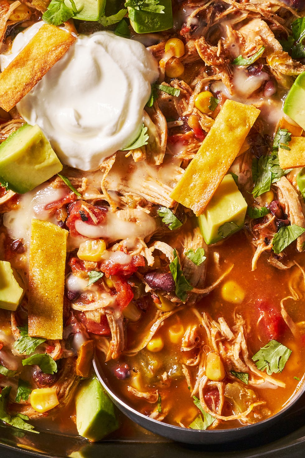 Slow-Cooker Chicken Tortilla Soup slow cooker chicken tortilla soup with sour cream, avocado slices, cheese and tortilla strips