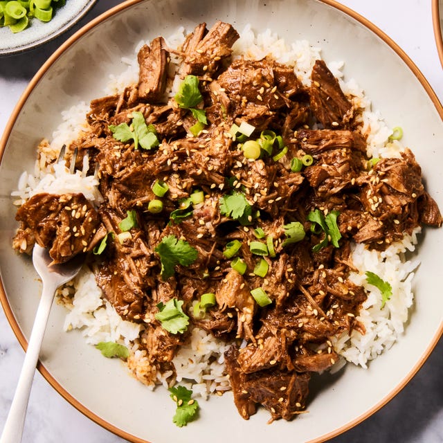 saucy korean style beef in a slow cooker with green onions
