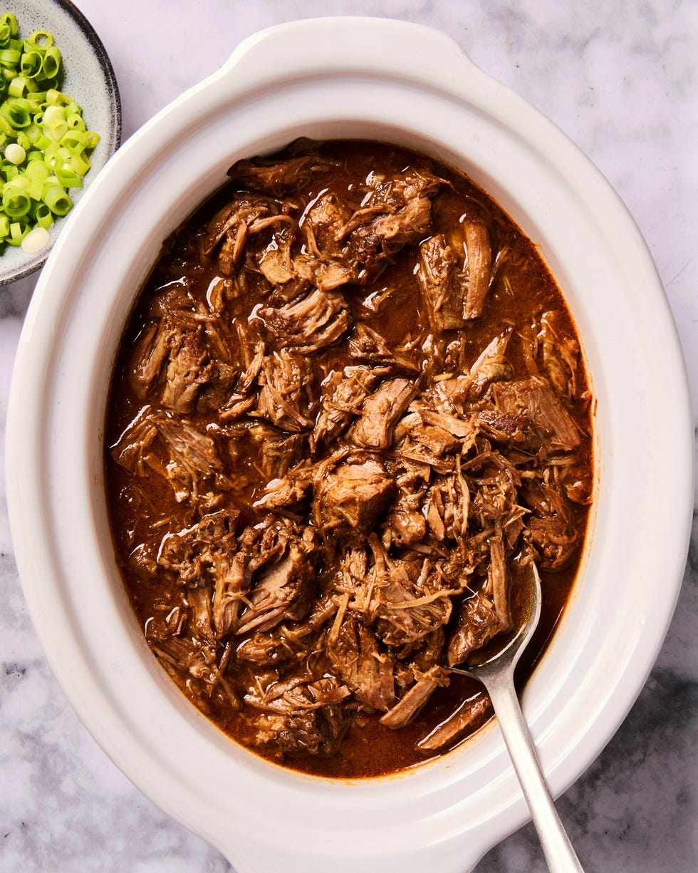 saucy korean style beef in a slow cooker with green onions