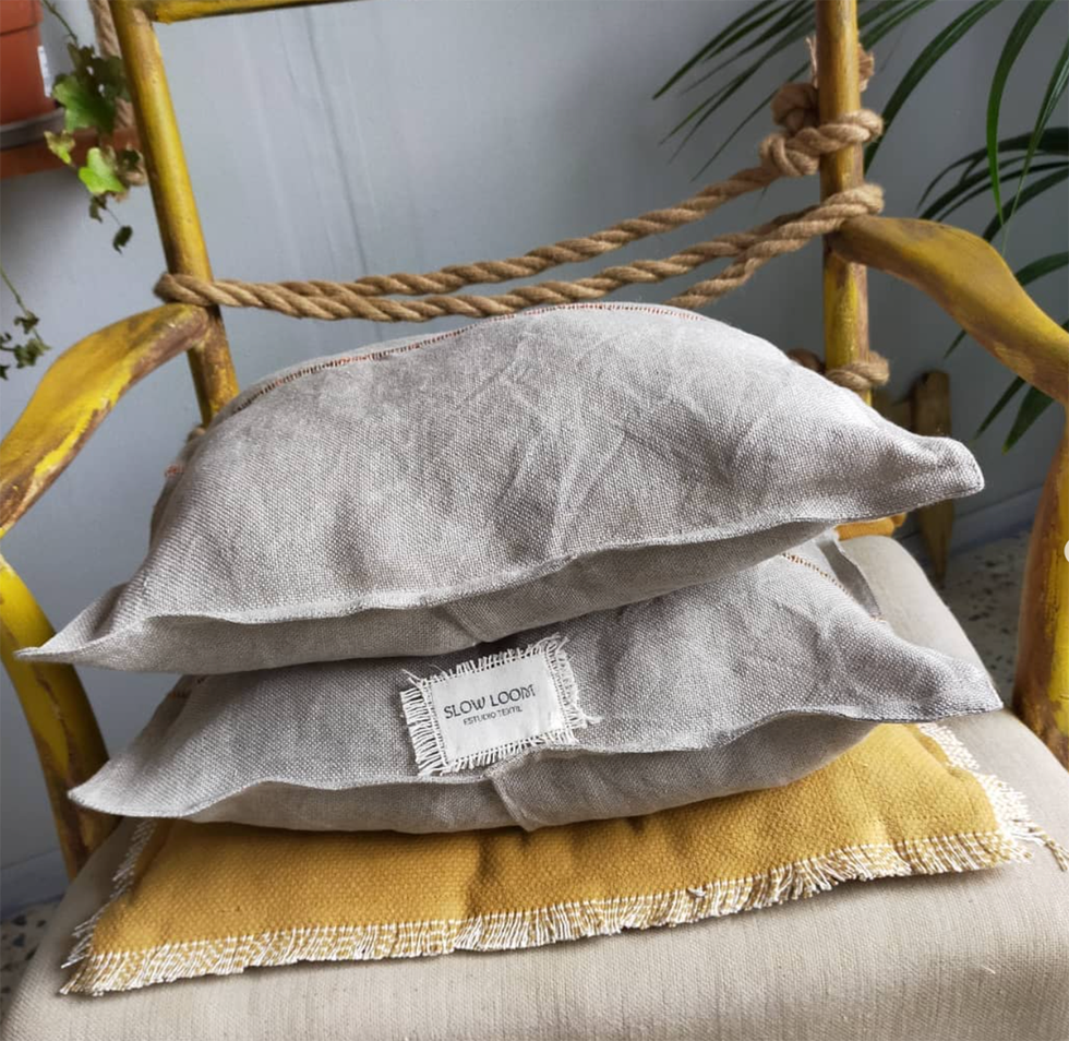 cojines de lino de slow loom sobre una silla de madera de color amarillo