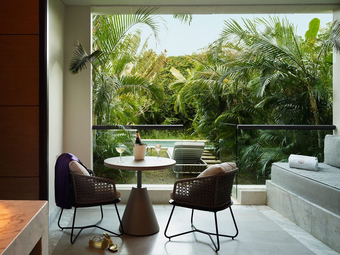 cozy seating area with view of lush greenery and a pool