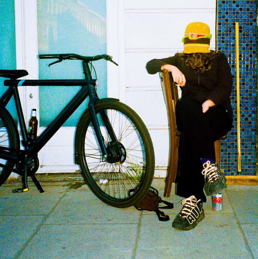 a person sitting on a chair next to a bicycle