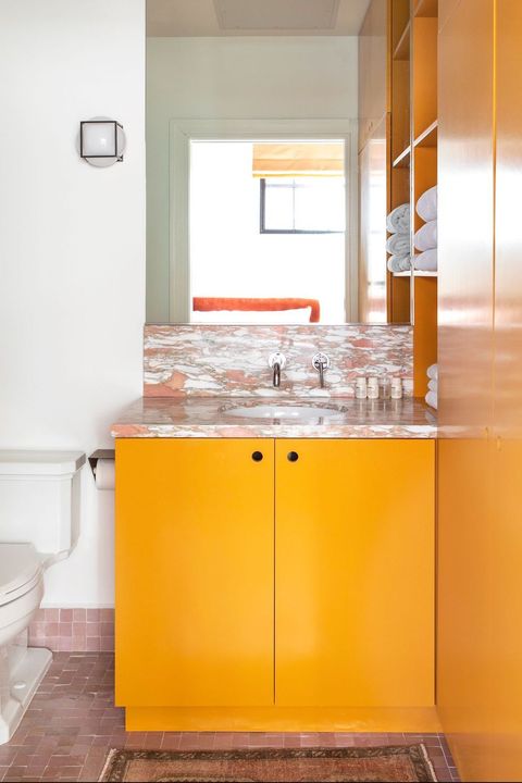 bathroom with pink marble and orange cabinets