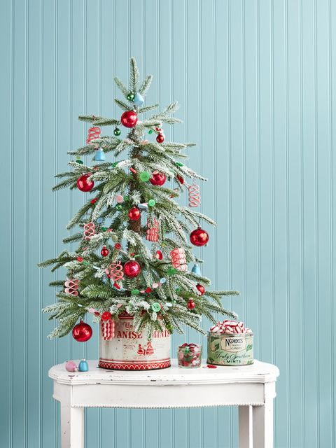 a flocked spruce and ribbon candy ornaments hit a nostalgic note and happy hued handmade button garland and vintage candy tin base add simple homespun charm
