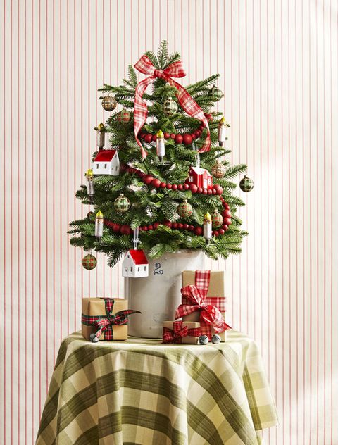 this mini balsam fir embraces traditional elements like a plaid bow and cranberry garland and tartan ornaments plus homey accents like clip on candlesticks and a stoneware crock serves as a classic base