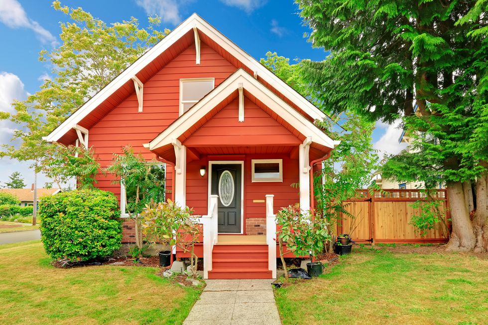 small coutnryside house exterior in bright red color with white