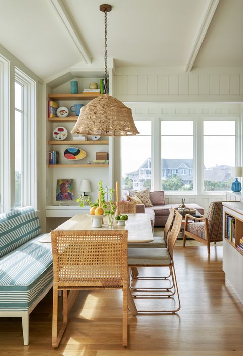 north carolina beach house designed by barrie benson interior design and architect meyer greeson paulin benson breakfast room warm wood on the furniture and open shelving tie the airy kitchen back to the ‘70s inspired louvers in the stairwell and dining room pendant made goods dining table tom dixon banquette hickory chair in perennials fabric dining chairs vintage harvey probber