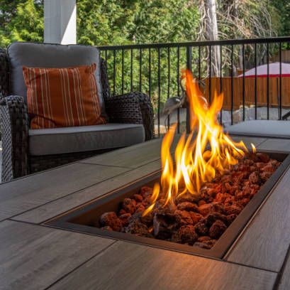 a spacious deck with a close up shot of a fire pit table heater
