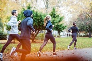 Small group of people running in the autumn park