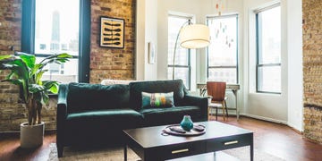 cozy living area featuring a dark green couch a coffee table and large windows