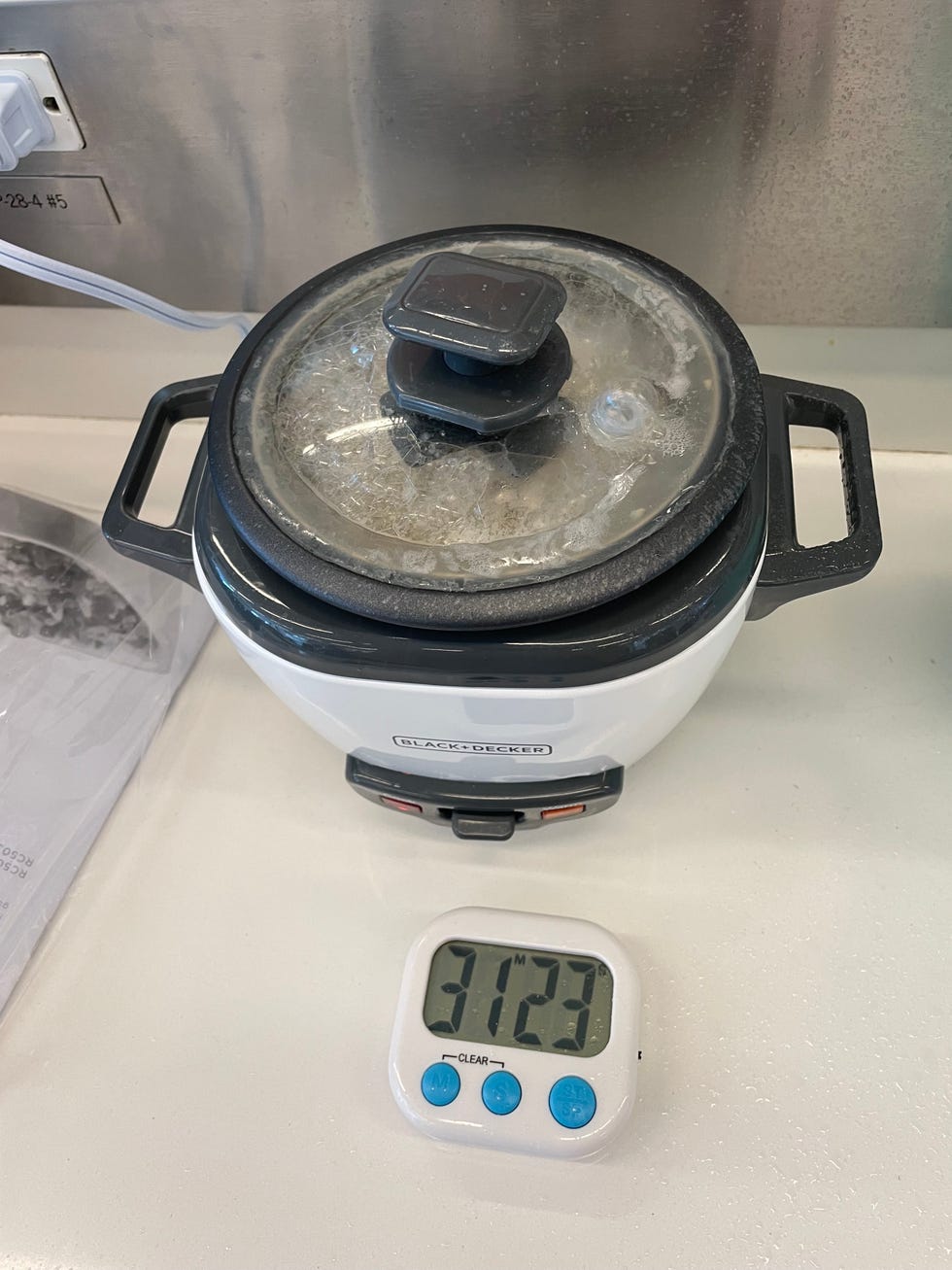 a small rice cooker with a timer displaying cooking time