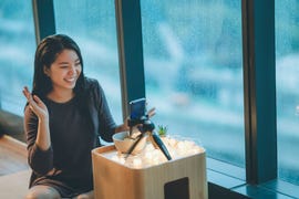 A person interacting with a smartphone camera setup in a cozy indoor environment