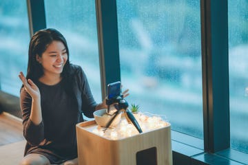 A person interacting with a smartphone camera setup in a cozy indoor environment