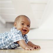 smiling baby crawling across the floor